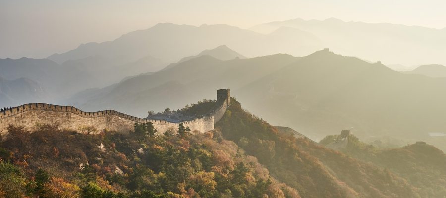 中国新一代天气雷达站全景，白色球形雷达罩矗立在山顶，周围是绿色植被，蓝天白云背景下展示气象探测设施